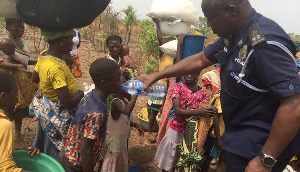 Chereponi District Police Commander, Chief Spt. Henry Amankwatia giving water to one of the children