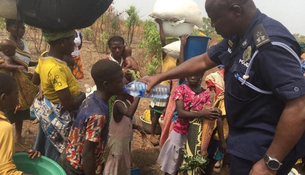Chereponi District Police Commander, Chief Spt. Henry Amankwatia giving water to one of the children