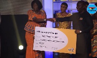 Naomi Esi Arku Amoah receiving a cheque for winning MTN's Hero of Change