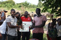 A member of the NDC presenting first aid boxes to an artisan