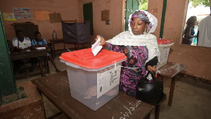 A woman casts her vote at a polling station during the parliamentary election in Cotonou, Benin
