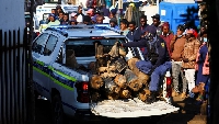 A police officer sits in the back of a police vehicle loaded with illegal mining equipment, after in