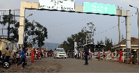 People walk past the Congo side of the Poids Lourd checkpoint at the border between Congo and Rwanda