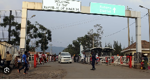 People walk past the Congo side of the Poids Lourd checkpoint at the border between Congo and Rwanda