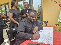 The GJA President signing a book of condolences in memory of Wofa KK