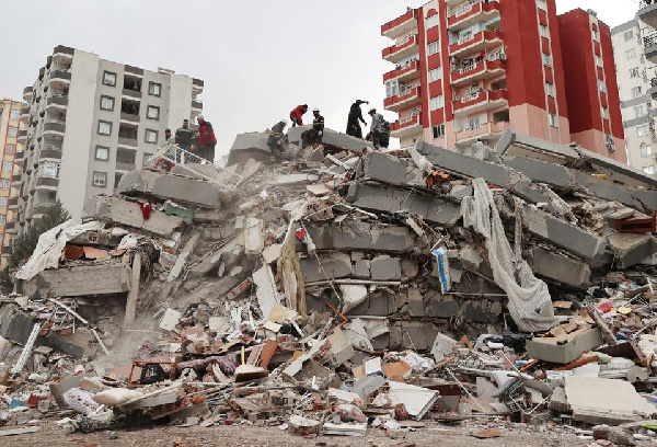 Rescue teams search through rubble of collapsed buildings in Turkey after a 7.8-magnitude earthquake