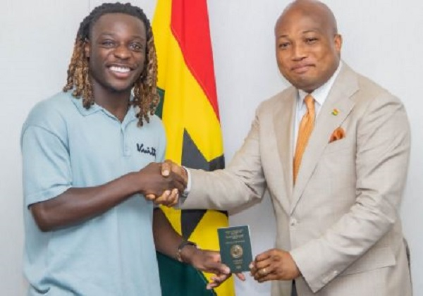 Jeremy Doku (L) receiving his Ghanaian passport from Ablakwa (R)