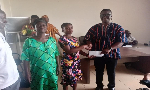 Ceaser Ofosu Acheampong, DCE, making the presentation to one of the beneficiaries
