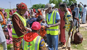 National Emergency Management Agency officials assist people affected by floodwaters in Maiduguri