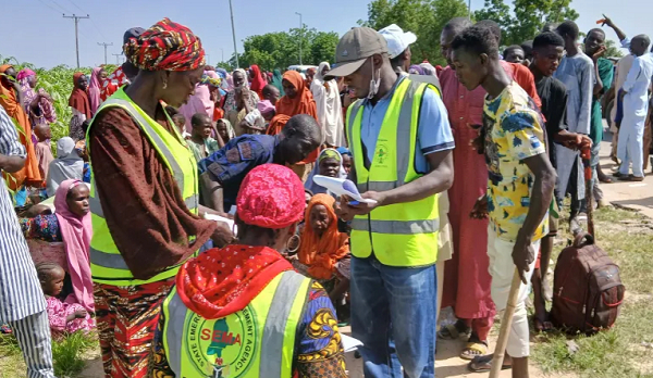 National Emergency Management Agency officials assist people affected by floodwaters in Maiduguri