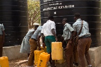Students queuing to fetch water from a polytank