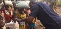 Chereponi District Police Commander providing water to thirsty children fleeing the community