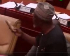 ABA Fuseini holding fried fish on the floor of Parliament