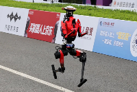 Humanoid robot Lightning runs after crossing the finish line.