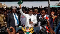 Opposition leader Raila Odinga holds a bible aloft after swearing an oath during a mock inauguration