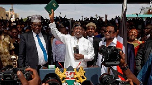 Opposition leader Raila Odinga holds a bible aloft after swearing an oath during a mock inauguration