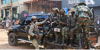 Members of the M23 rebel group gather on their pick-up truck after recovering guns