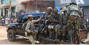Members of the M23 rebel group gather on their pick-up truck after recovering guns