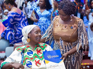 Vice President Opoku-Agyemang presents a citizenship certificate to a new Ghanaian from the diaspora