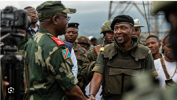 Willy Ngoma, spokesman of the M23, right, shakes hands with Emmanuel Kaputa (EACRF)