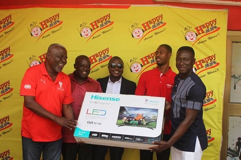 Jacob Tokoli being presented the 32-inch LED television by officials from Happy FM