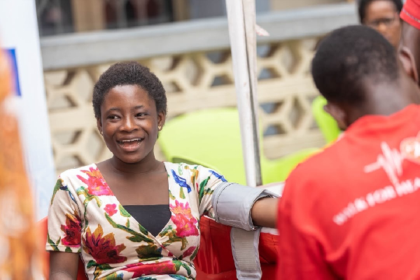 A lady smiling while receiving treatment during Telecel's free health screening execrise