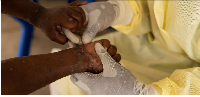 A nurse takes a sample from a child declared a suspected case of Mpox