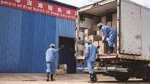 Workers load anchovy products into a truck in Kwale, Kenya