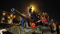 People stand on a Turkish army tank in Ankara, Turkey July 16, 2016