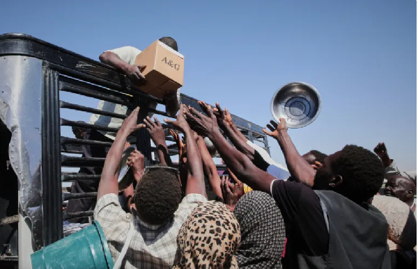 Sudanese families displaced from el-Fasher reach out as aid workers distribute food supplies