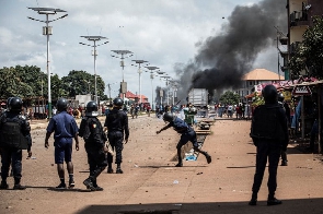 A Police Officer Throws A Stone At Protesters, During A Mass Protest In Conakry In October 2020.png