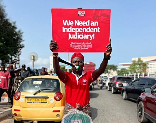Protestor holds up a placard at 'Save the Judiciary Demo'