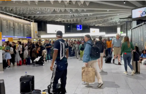 People gather at the airport in Frankfurt as flights are cancelled or delayed due to floods