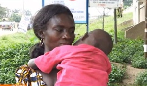 Monica Nyarko carrying her 4-year-old child who was defiled by an adult male.