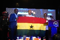 Black Stars skipper Dede Ayew and GFA boss receive a flag from president Akufo-Addo