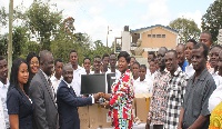 Representatives of GCB Bank present computers to the management of the school