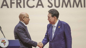 South Korean President Yoon Suk Yeol (right) shakes hands with Mohamed Ould Ghazouani