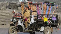 An Egyptian broom vender drives his motorized tricycle in Cairo