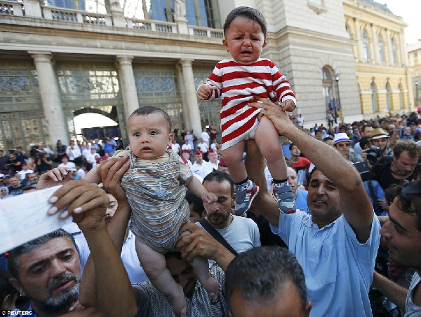 Migrants raised their babies during protest at the Keleti railway station in Budapest Photo: Reuters