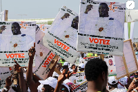 Supporters of Guinean leader and presidential candidate Mamadi Doumbouya hold posters of him