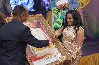 Ohemaa Mercy presenting the dress to Dr. Anthony Cudjoe