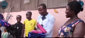 Ibrahim Oppong Kwarteng presents the items to Sister Aggie and her sons