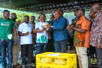 President Mahama (third from right) being presented with a fowl during his visit to the farm