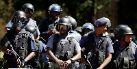 South African police exit after a raid on a home in Johannesburg