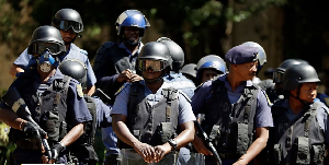 South African police exit after a raid on a home in Johannesburg
