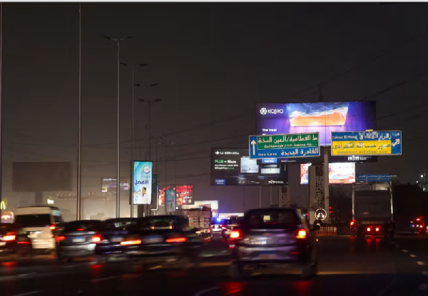 Vehicles drive past brightly lit billboards in Cairo, Egypt, September 16, 2025