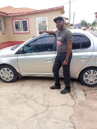 Coach Sarpong standing beside his new car