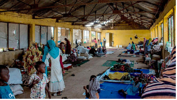 Women and children gather in a building at a camp for the internally displaced in al-Suwar,