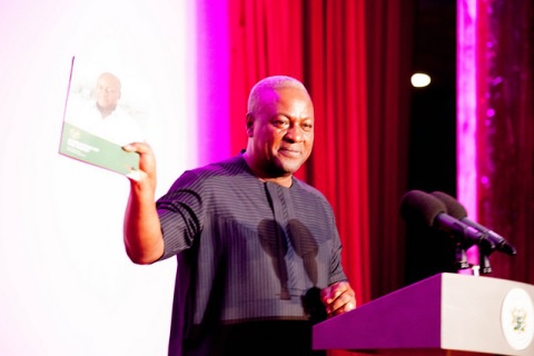 President John Dramani Mahama holding a copy of the Book