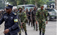 Rwandan security officers escort members of the armed forces of the DRC